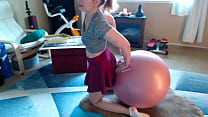 Morning yoga ball stretching in a short skirt